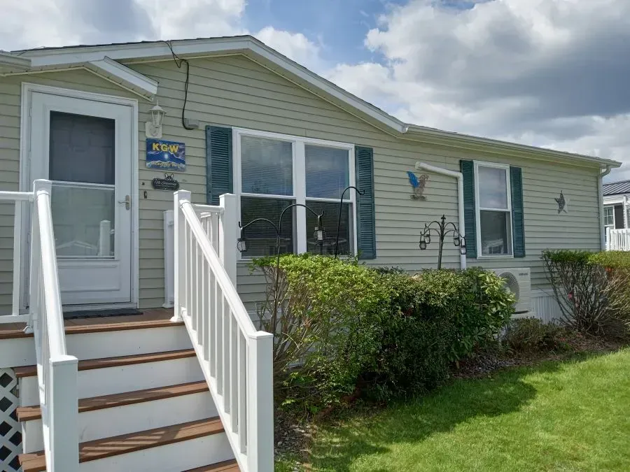 A mobile home with stairs leading up to the front door
