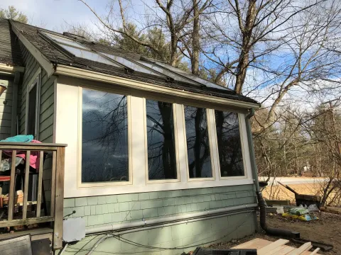 A house with a lot of windows and solar panels on the roof.
