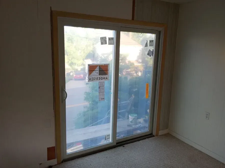 A sliding glass door is being installed in a room.