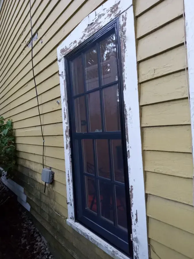 A yellow house with a black window on the side