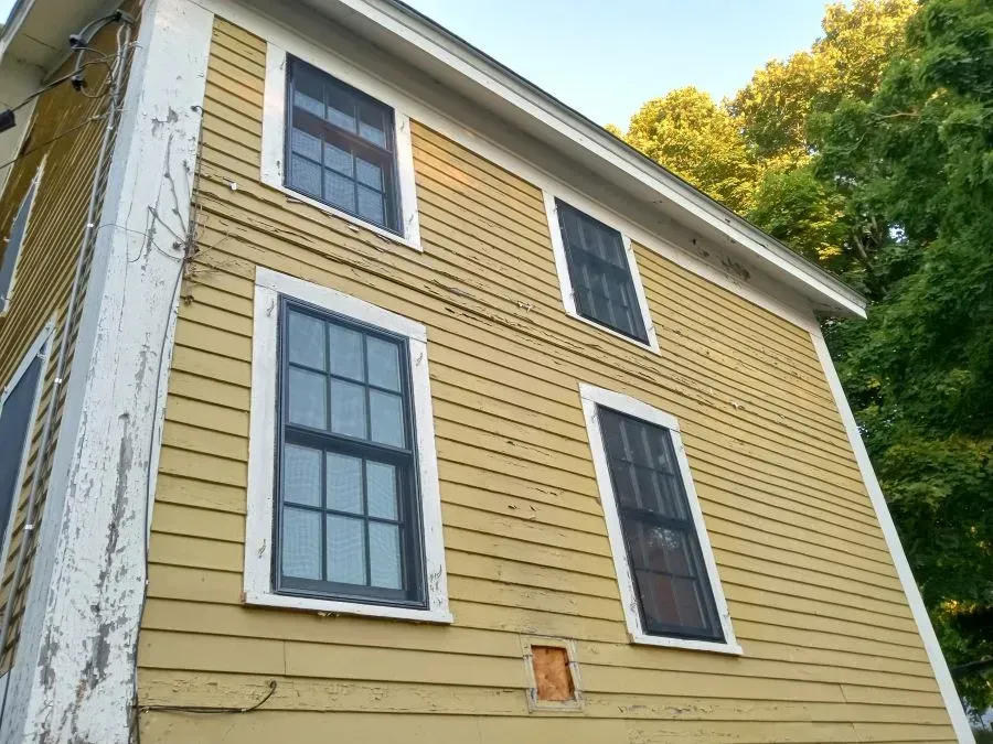 A yellow house with white trim and black windows