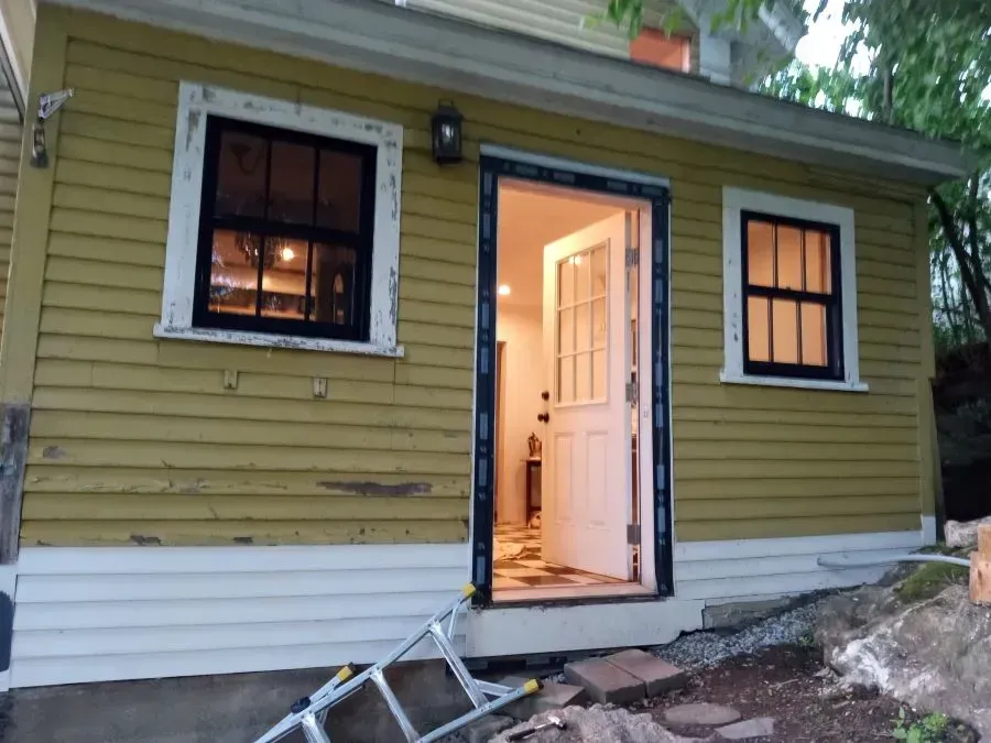 A yellow house with a ladder in front of it