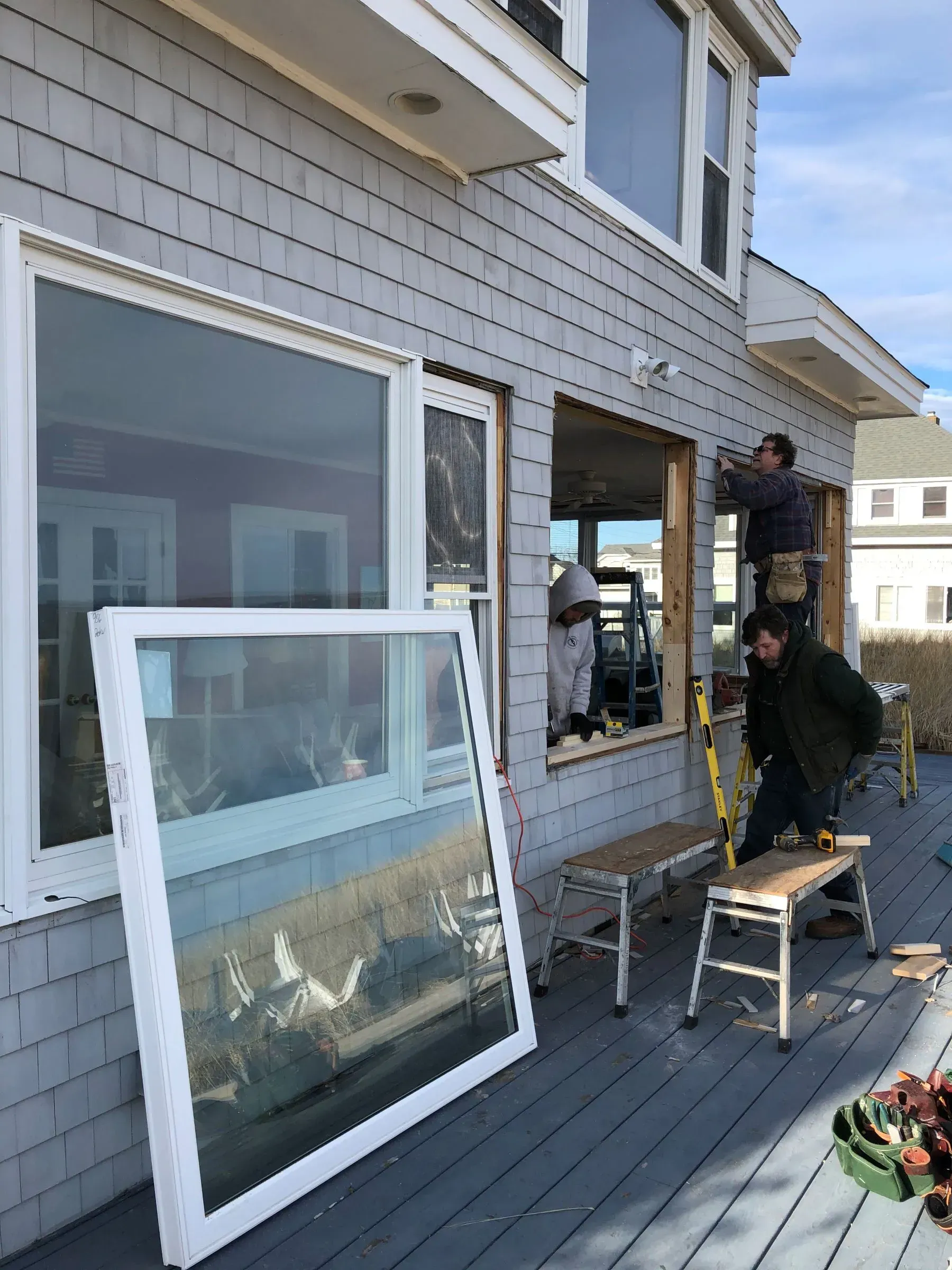 A group of people are working on a house.