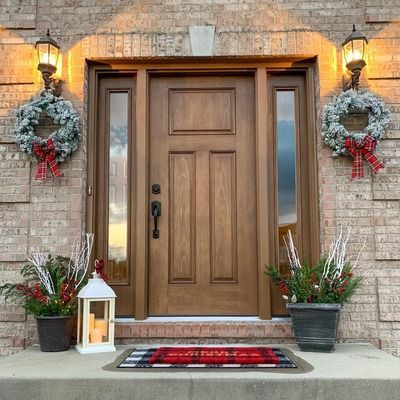 Dark wooden front door with glass panels, centered in a light gray doorway.