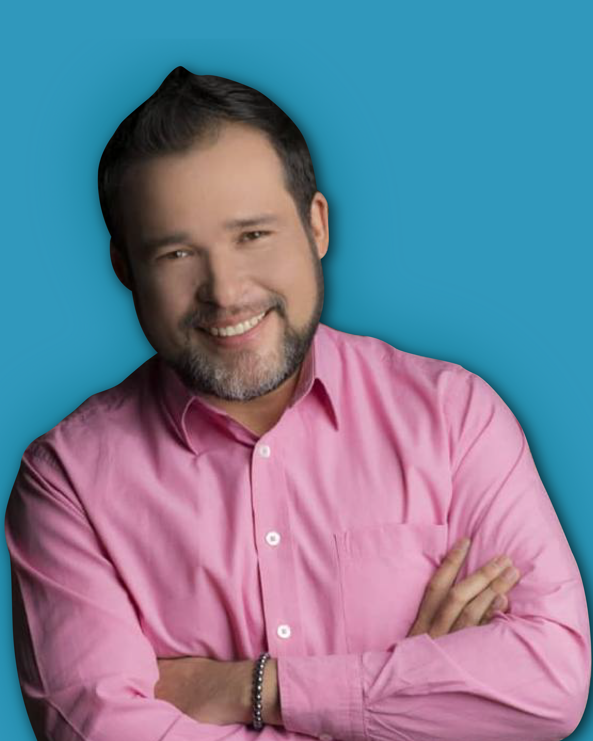 Hombre con barba, brazos cruzados, sonriente, vistiendo una camisa rosa sobre un fondo azul.