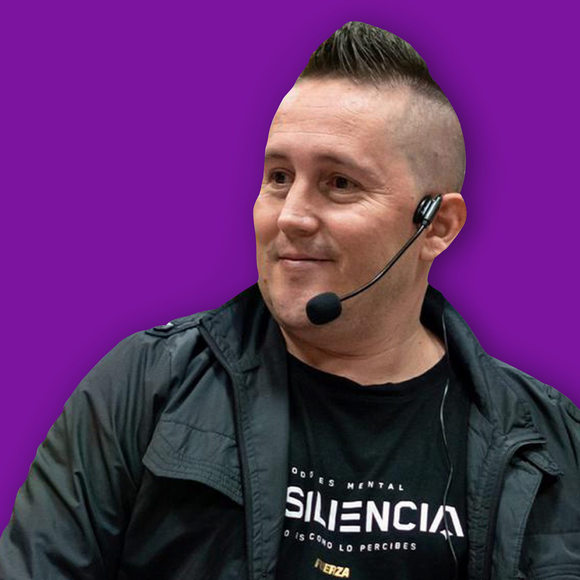 Hombre con mohawk y micrófono, vestido con chaqueta y camisa negras, sobre fondo morado.