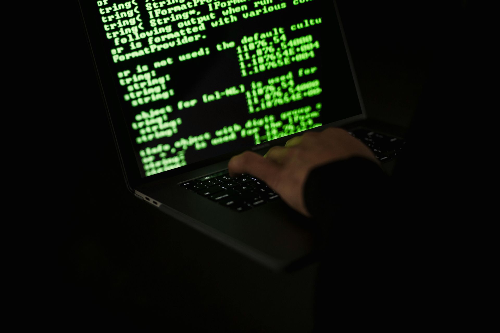 Cyber criminal working on a laptop computer