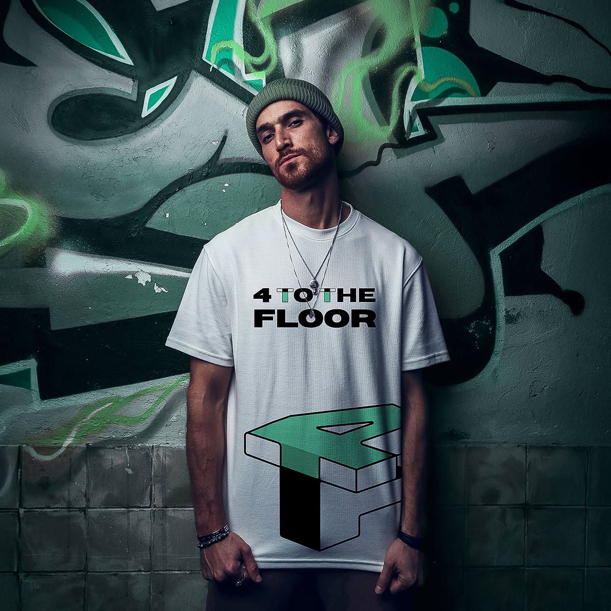 Person standing in a graffiti alley, wearing a white “4 THE FLOOR” T-shirt, looking at the camera.