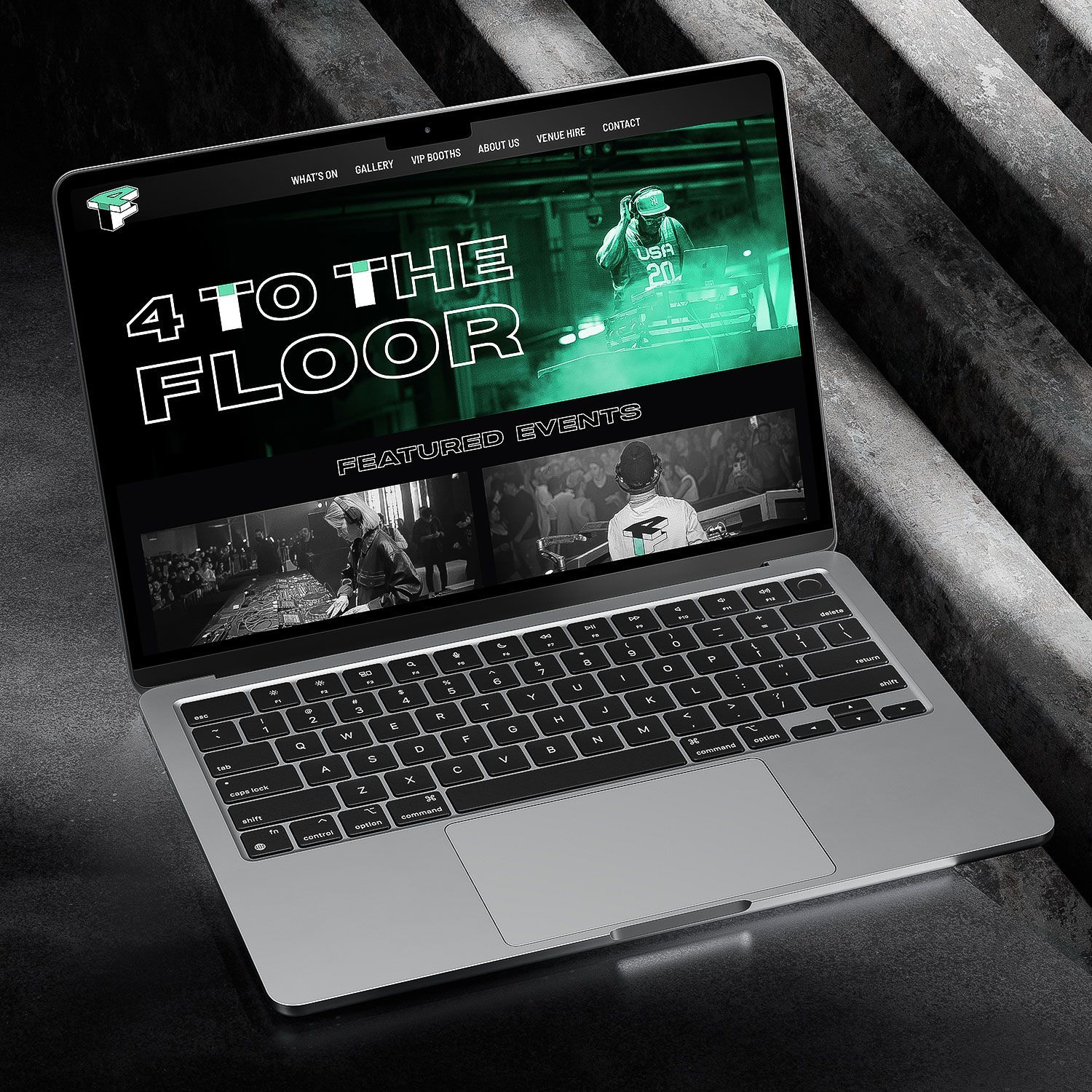 Laptop displaying a dark green website mockup on a gray background