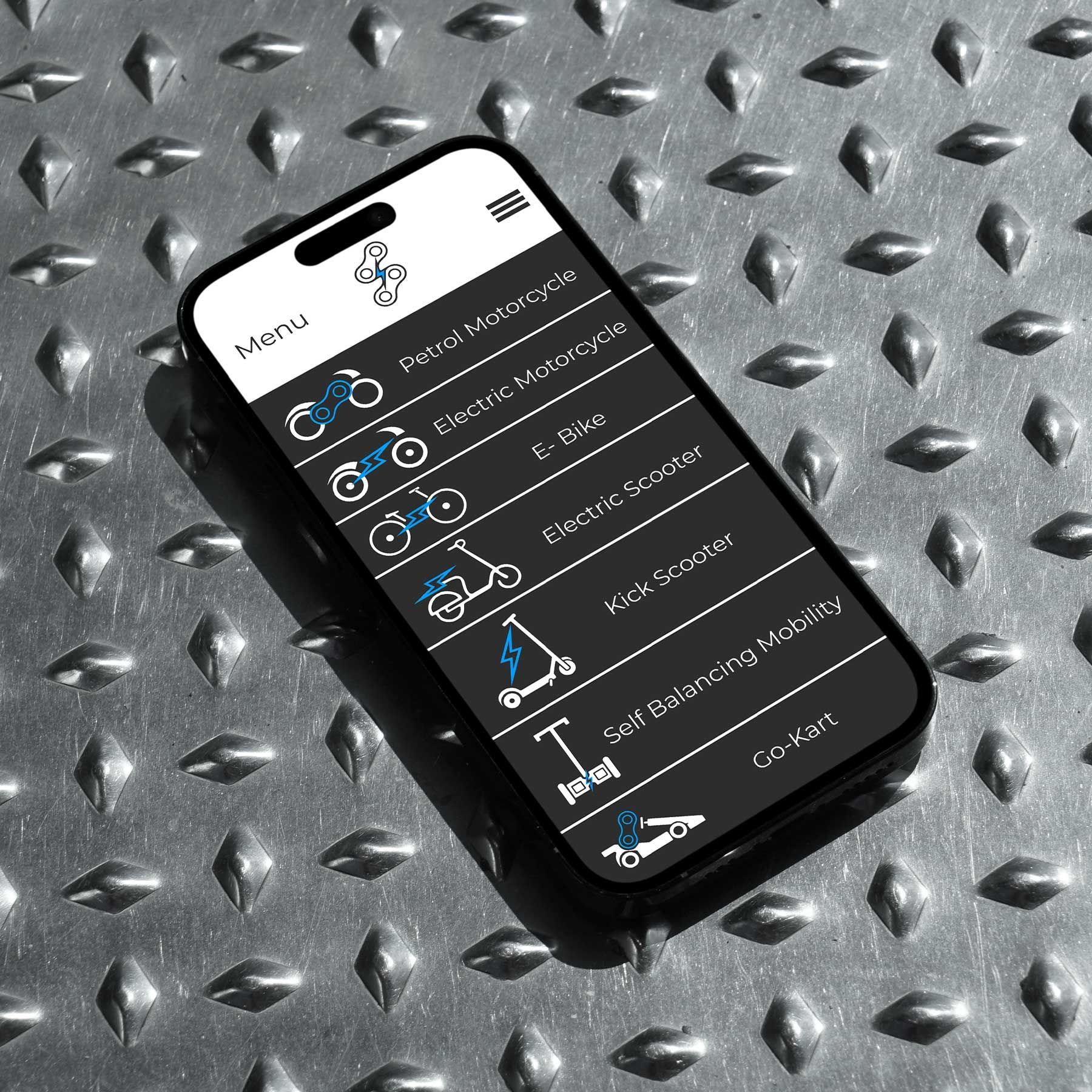 Black smartphone displaying a dark app screen, lying diagonally on a silver textured metal surface.