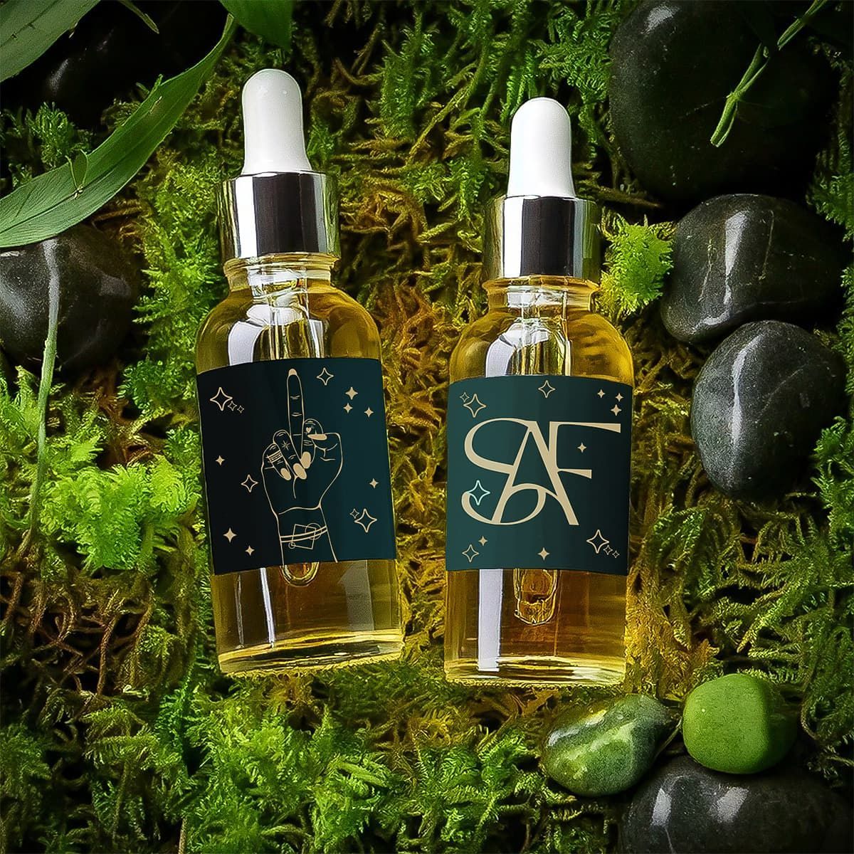 Two amber dropper bottles with dark labels on moss and stones