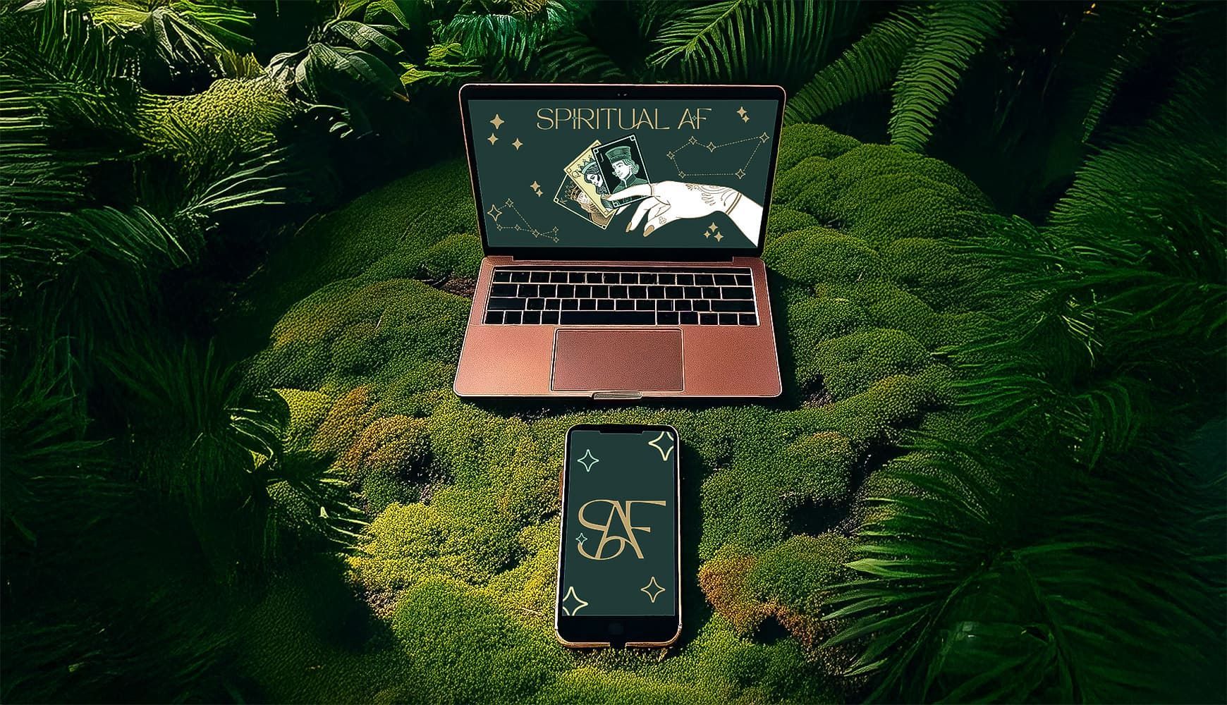 Open laptop and smartphone on lush green foliage with a dark map on the laptop screen