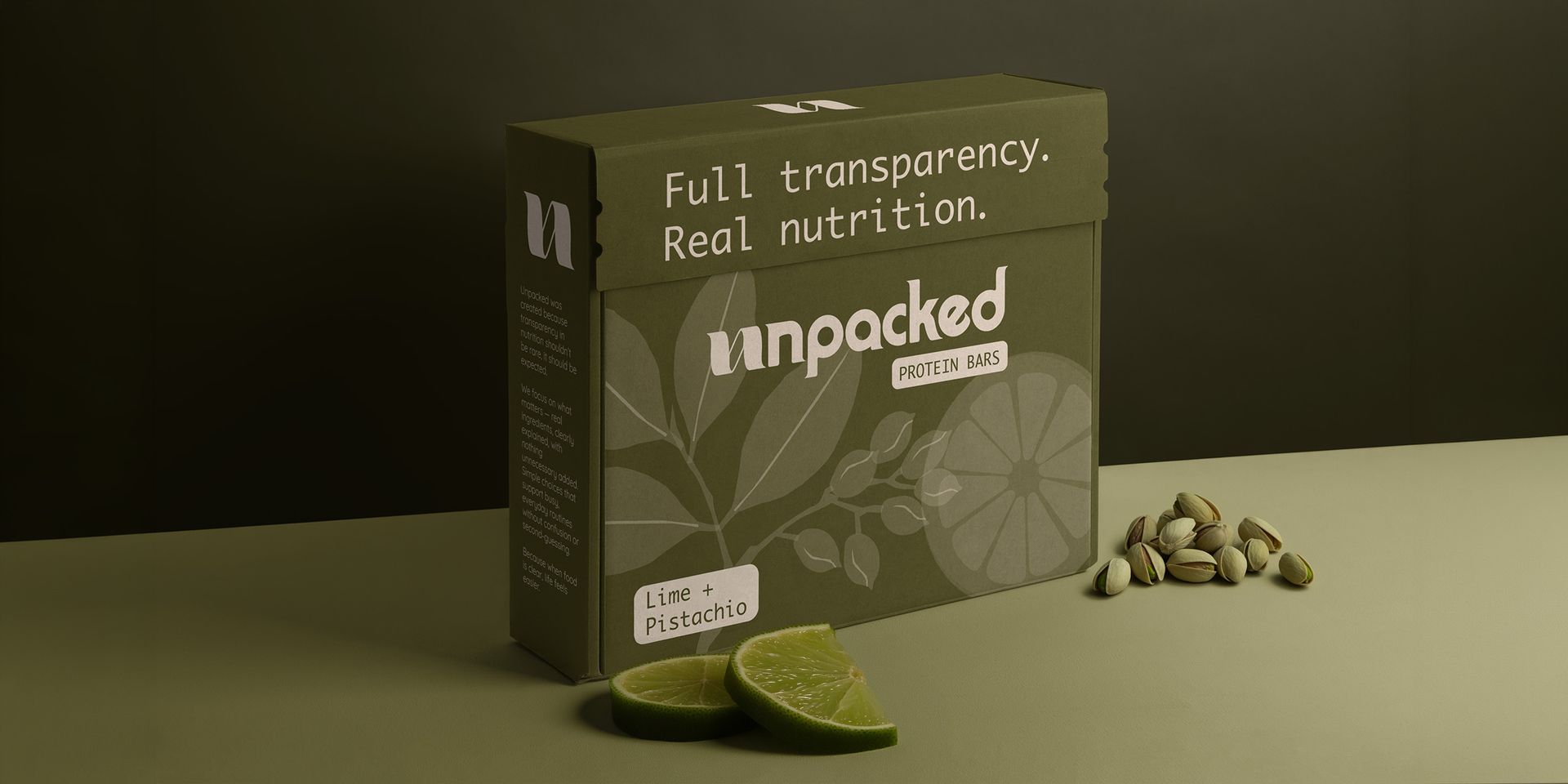 Green lime tea box with sliced limes and tea leaves on a dark surface