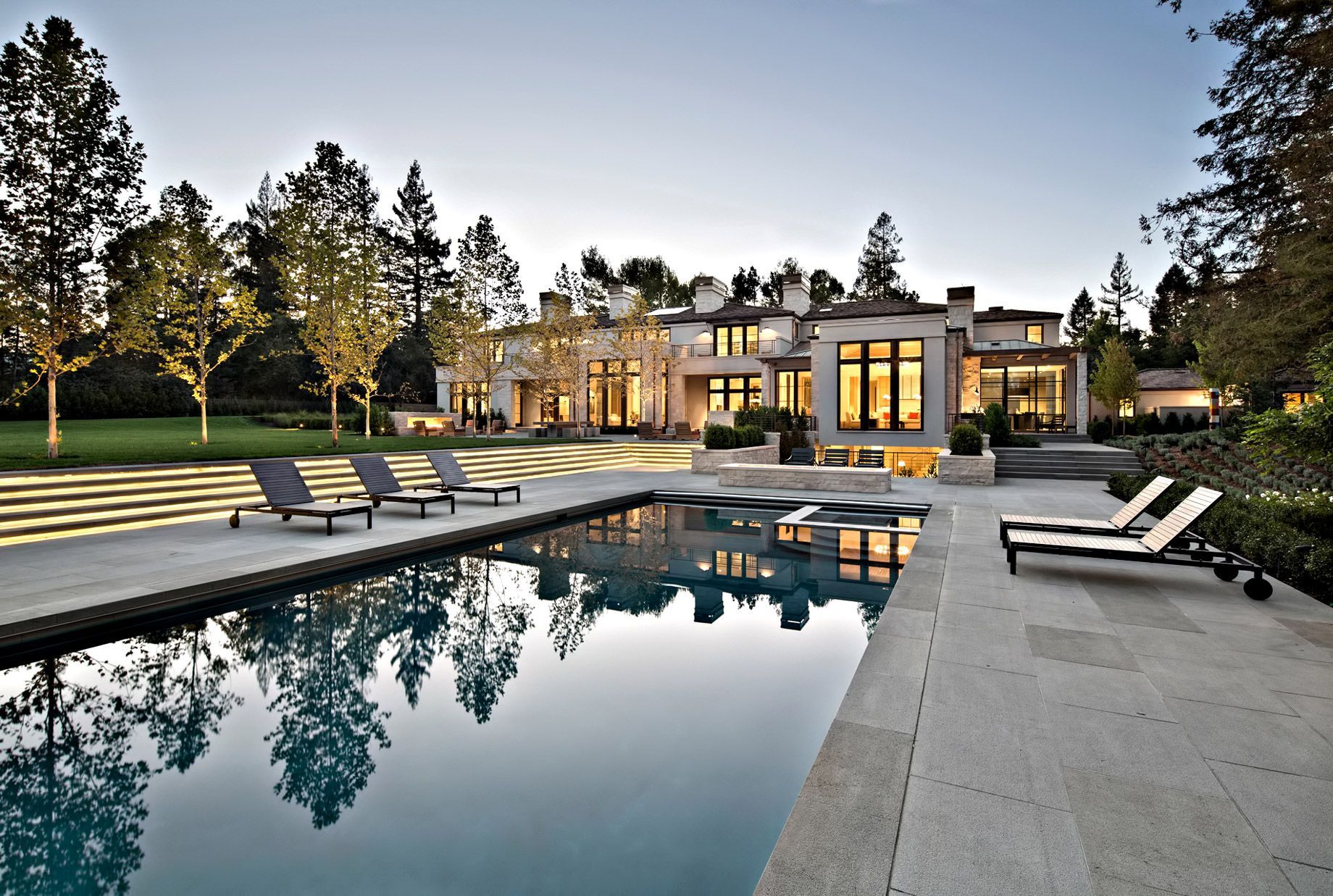 A large house with a large swimming pool in front of it