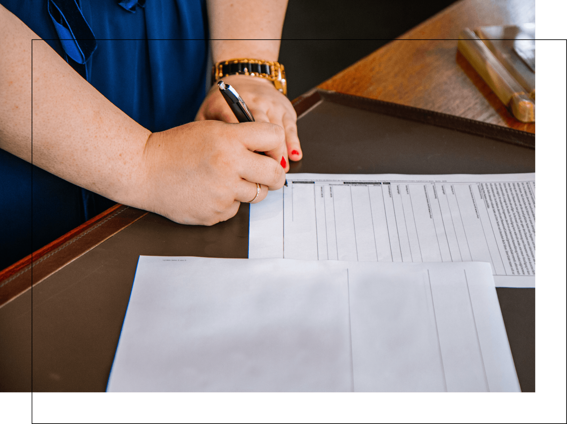 A woman is writing on a piece of paper with a pen.