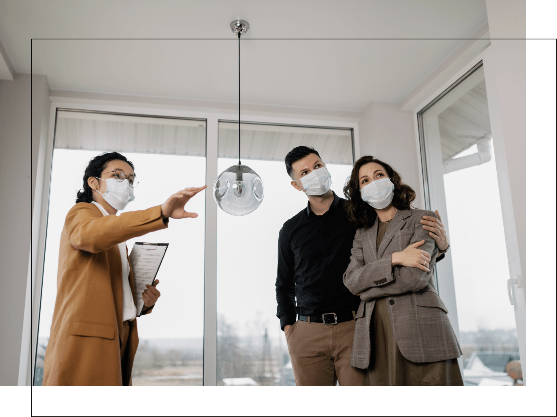 A man and a woman wearing face masks are looking at a house.