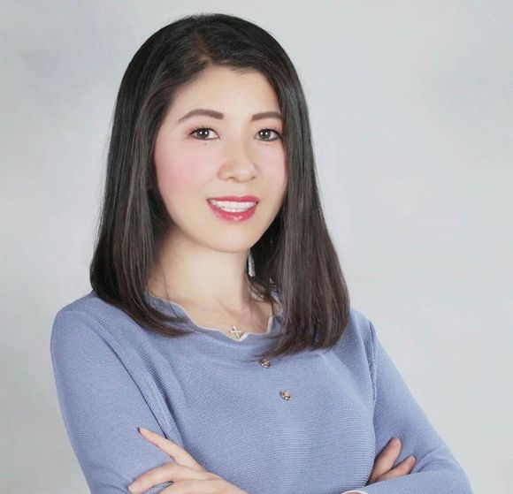A woman in a blue sweater with her arms crossed