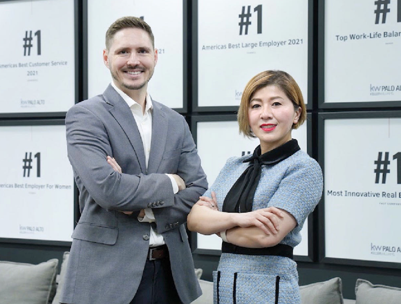 A man and a woman are standing next to each other with their arms crossed.
