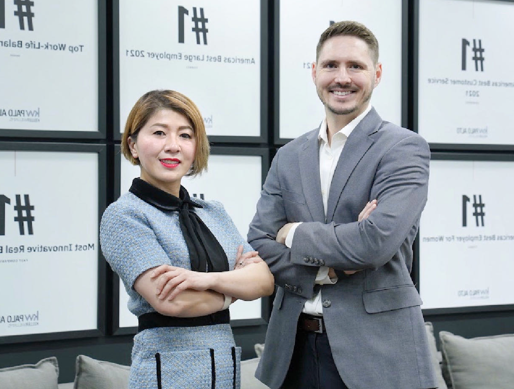 A man and a woman are standing next to each other with their arms crossed.