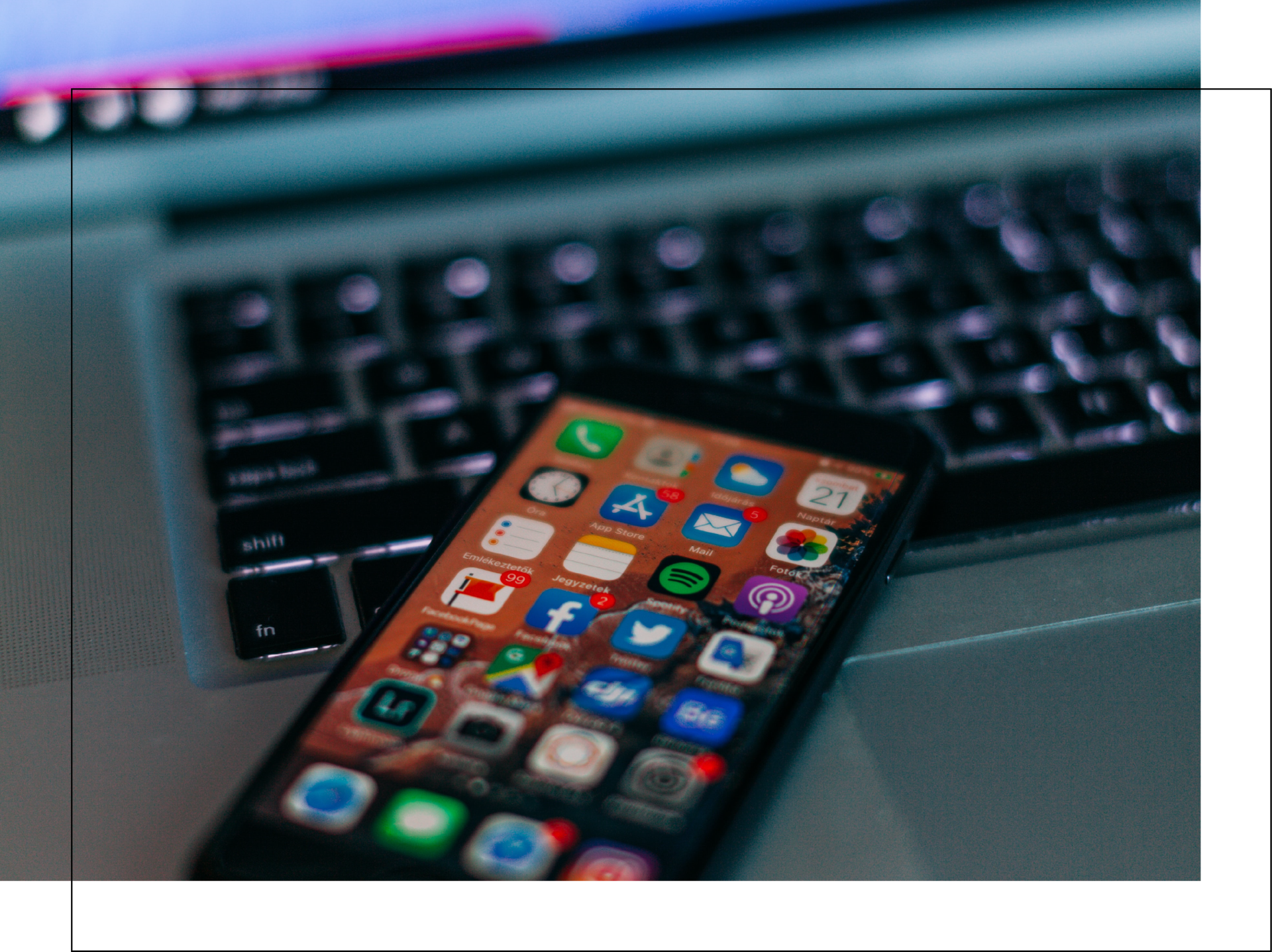 A cell phone is sitting on top of a laptop keyboard.