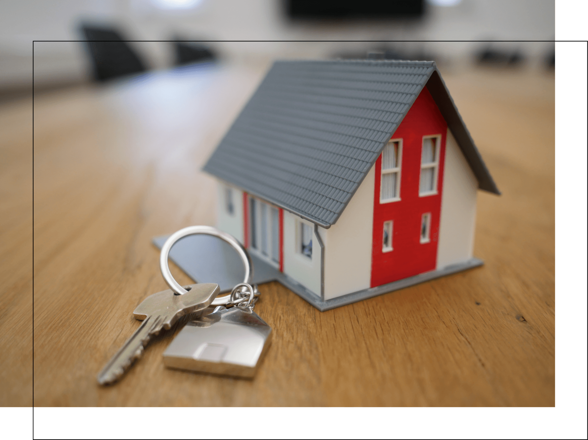A model house and keys on a wooden table