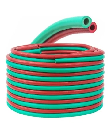 Mangueras de soldadura enrolladas de color rojo y verde, para transportar oxígeno y combustible.