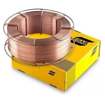 Bobina de alambre de soldadura, color cobre, encima de una caja ESAB amarilla.