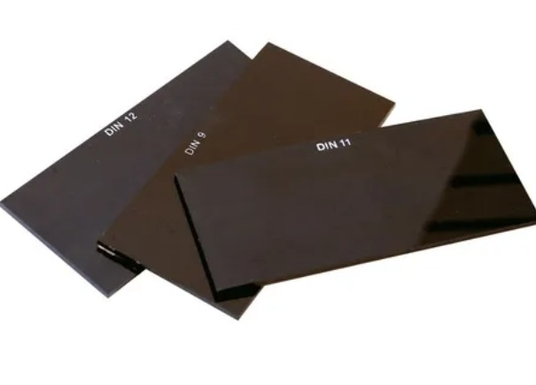 Tres filtros de lente de soldadura rectangulares oscuros etiquetados como DIN 9, 11 y 12.