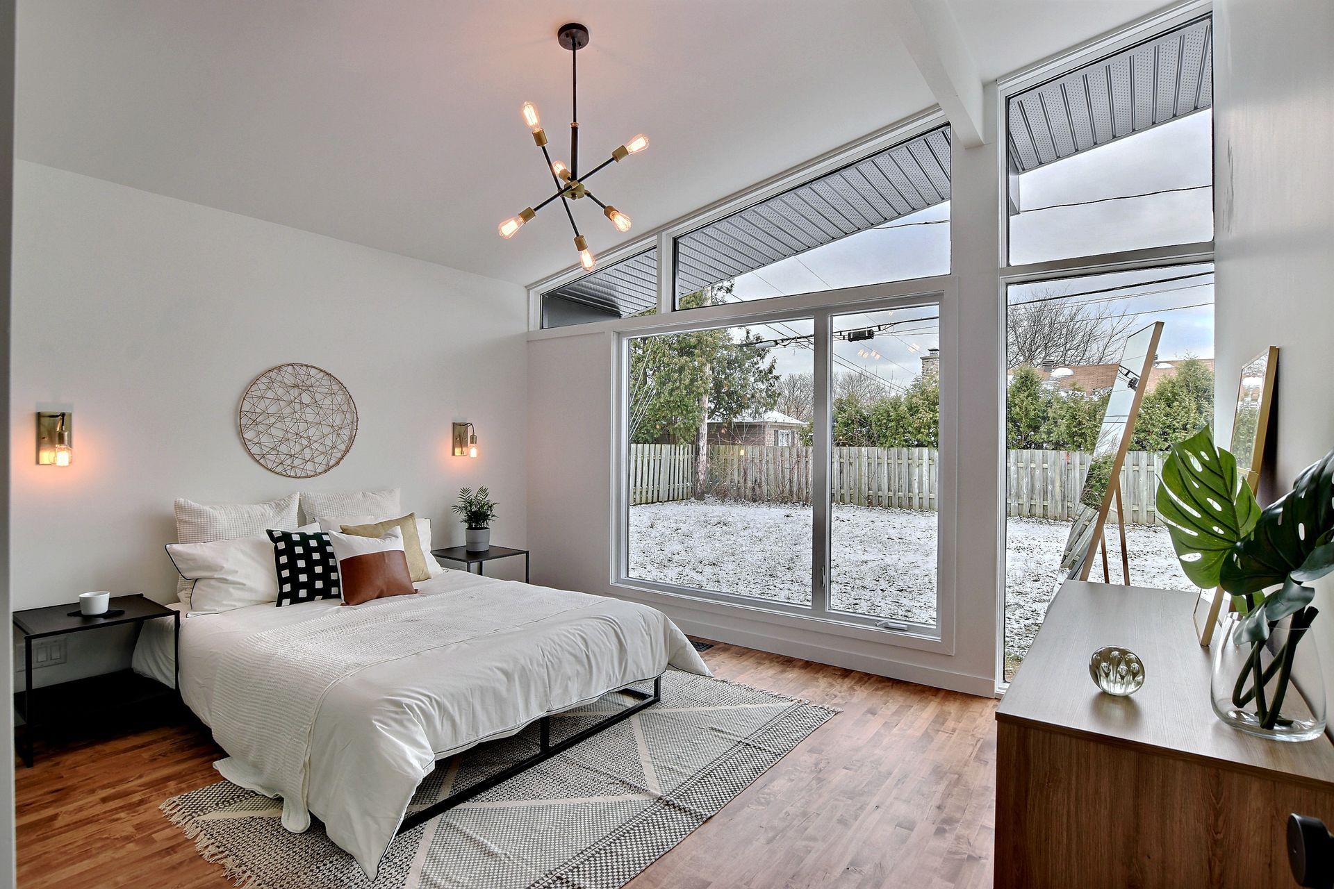 Une chambre avec un grand lit et beaucoup de fenêtres.