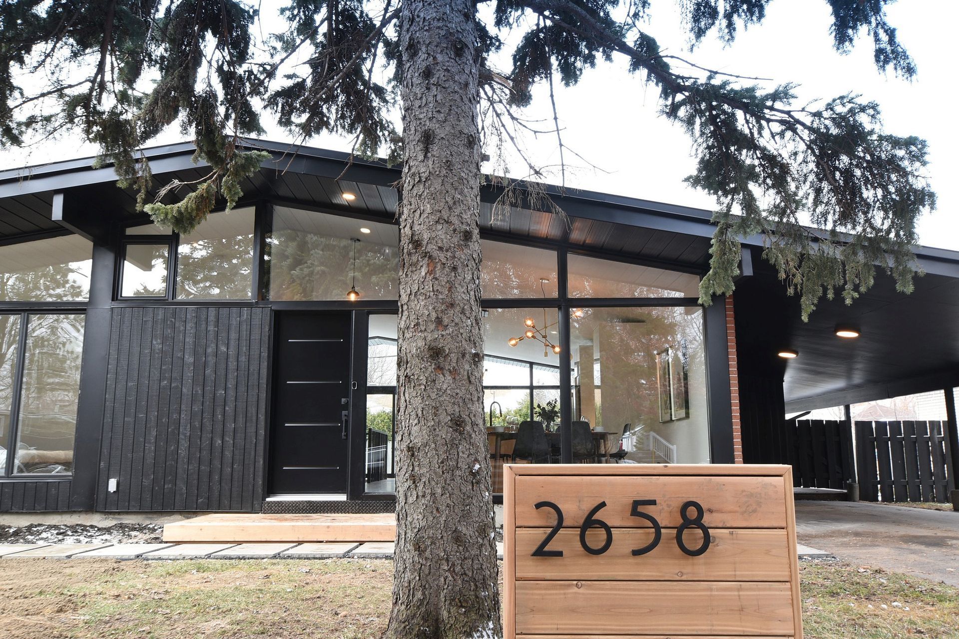 Une maison avec un panneau en bois devant qui dit 2658.
