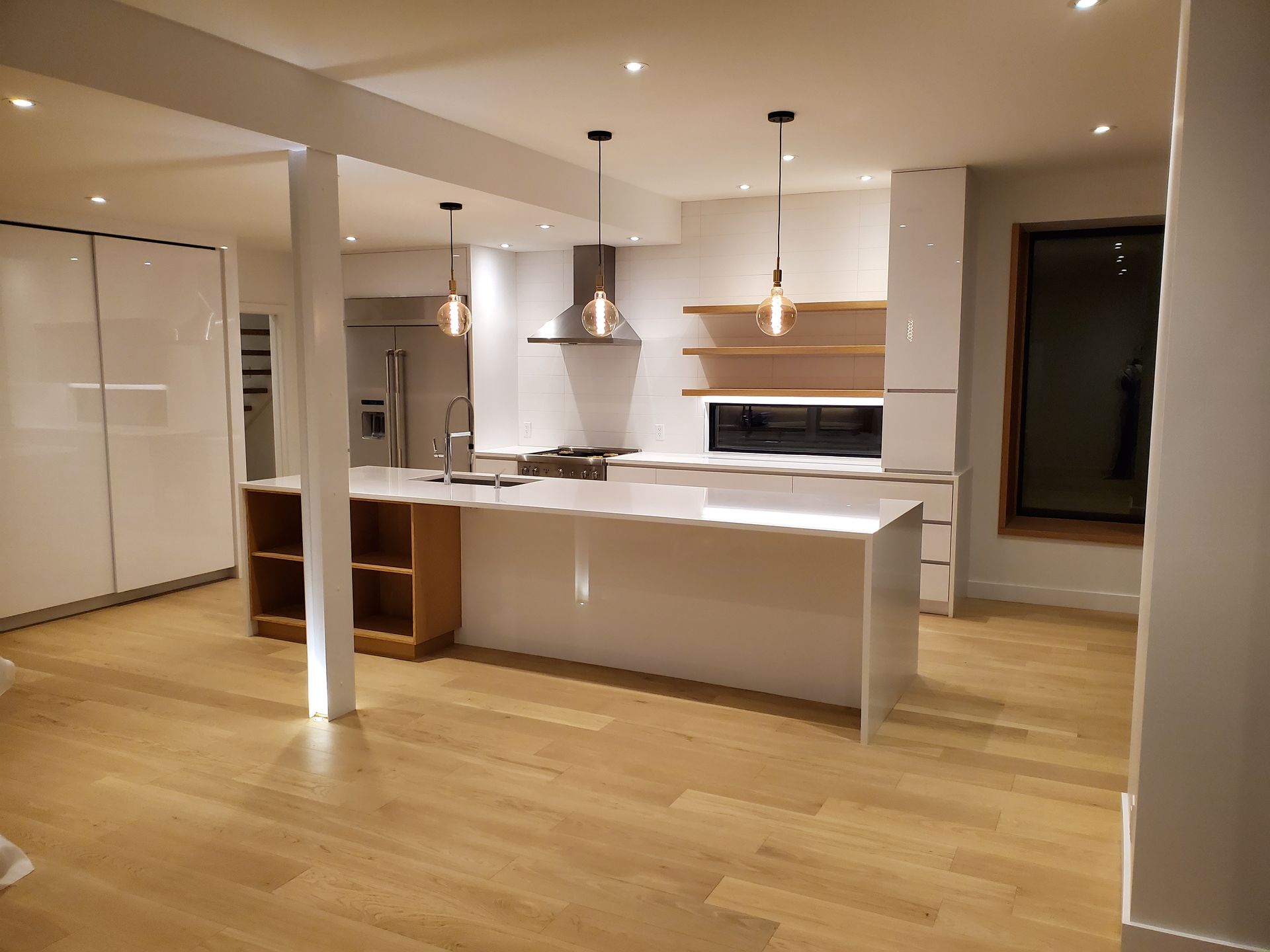 Une cuisine avec des armoires blanches et du parquet