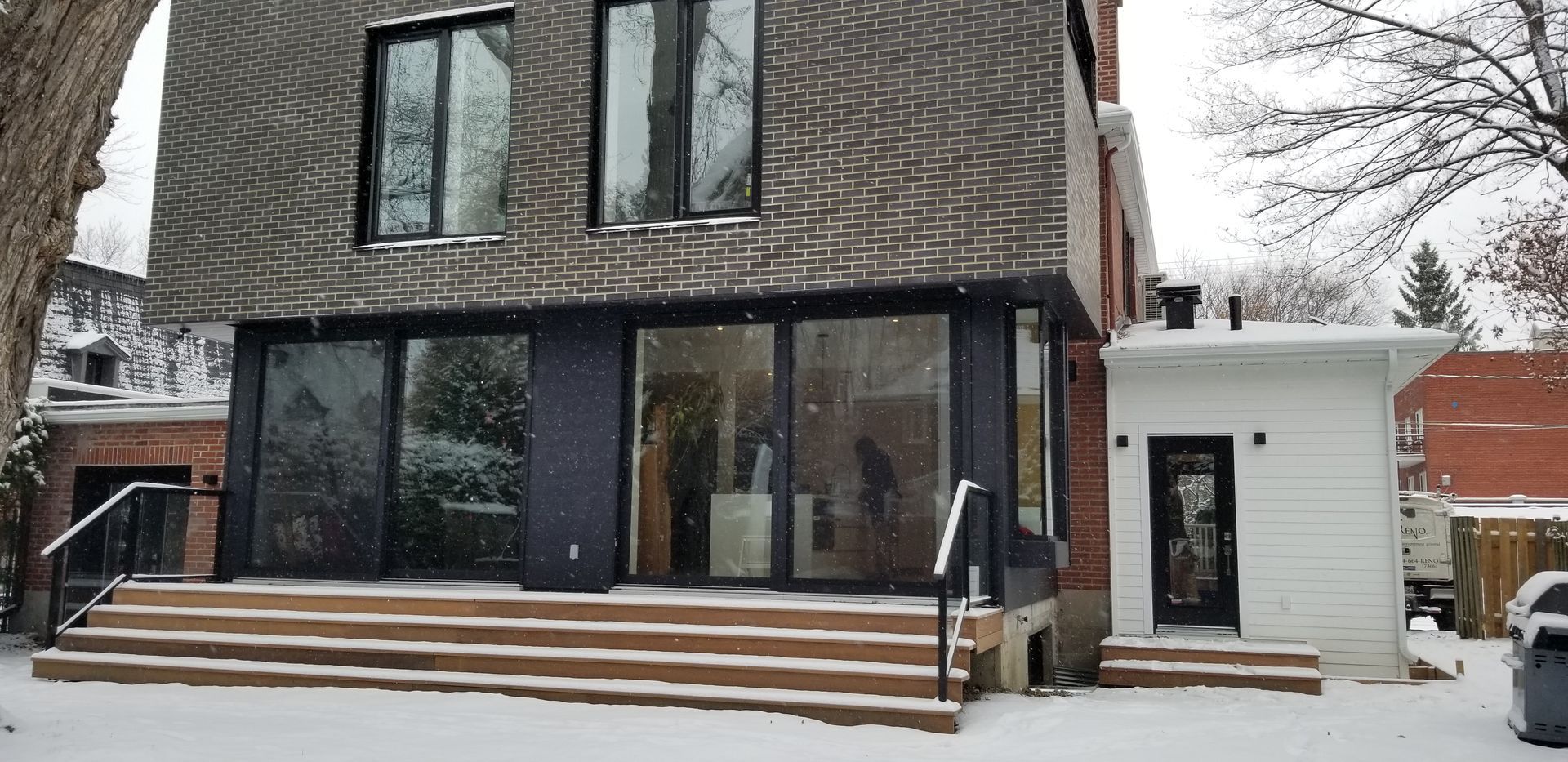 Une maison avec beaucoup de fenêtres et d'escaliers dans la neige.