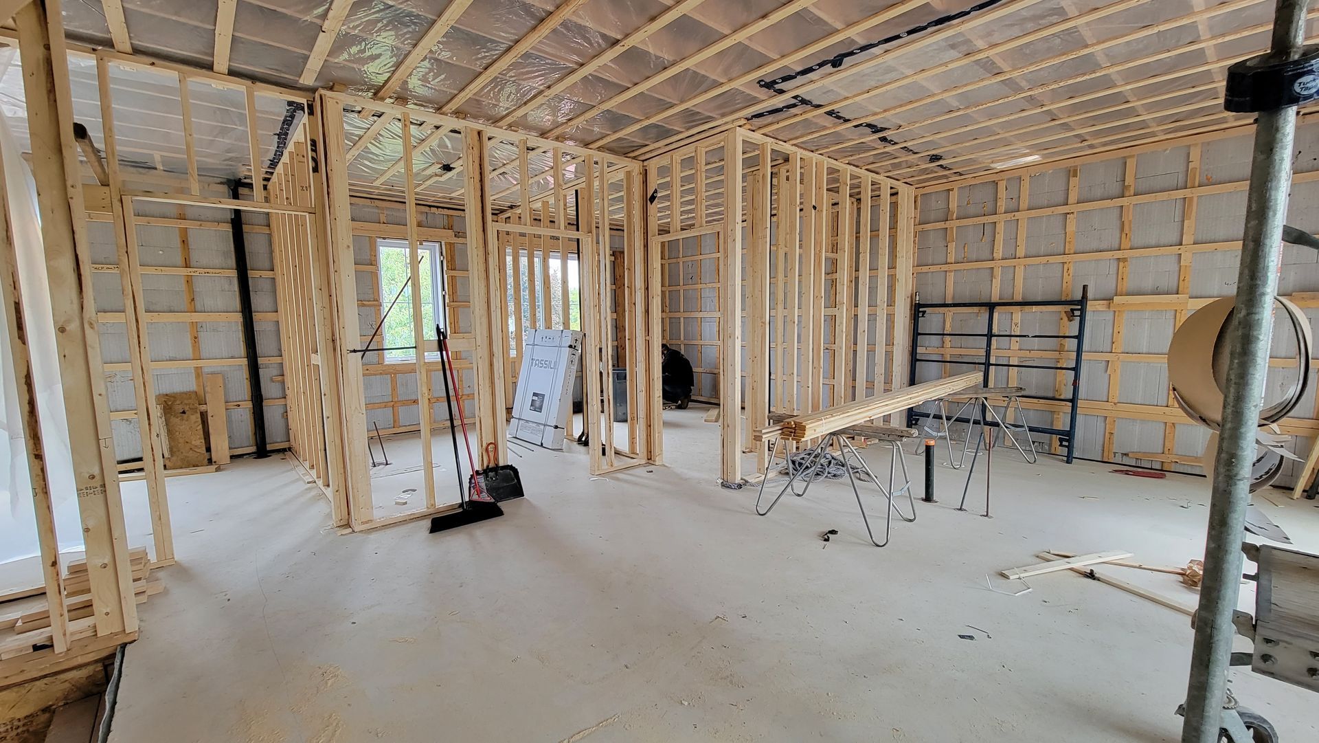 Une grande pièce avec beaucoup de cadres en bois et d'échafaudages dans une maison en construction.
