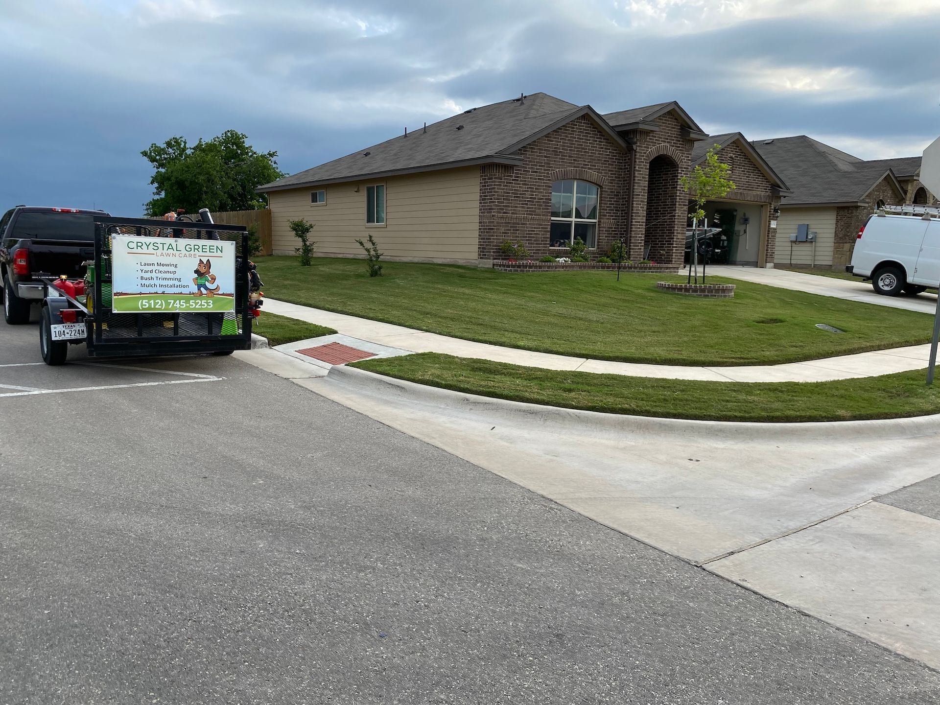 a truck is parked on the side of the road in front of a house .
