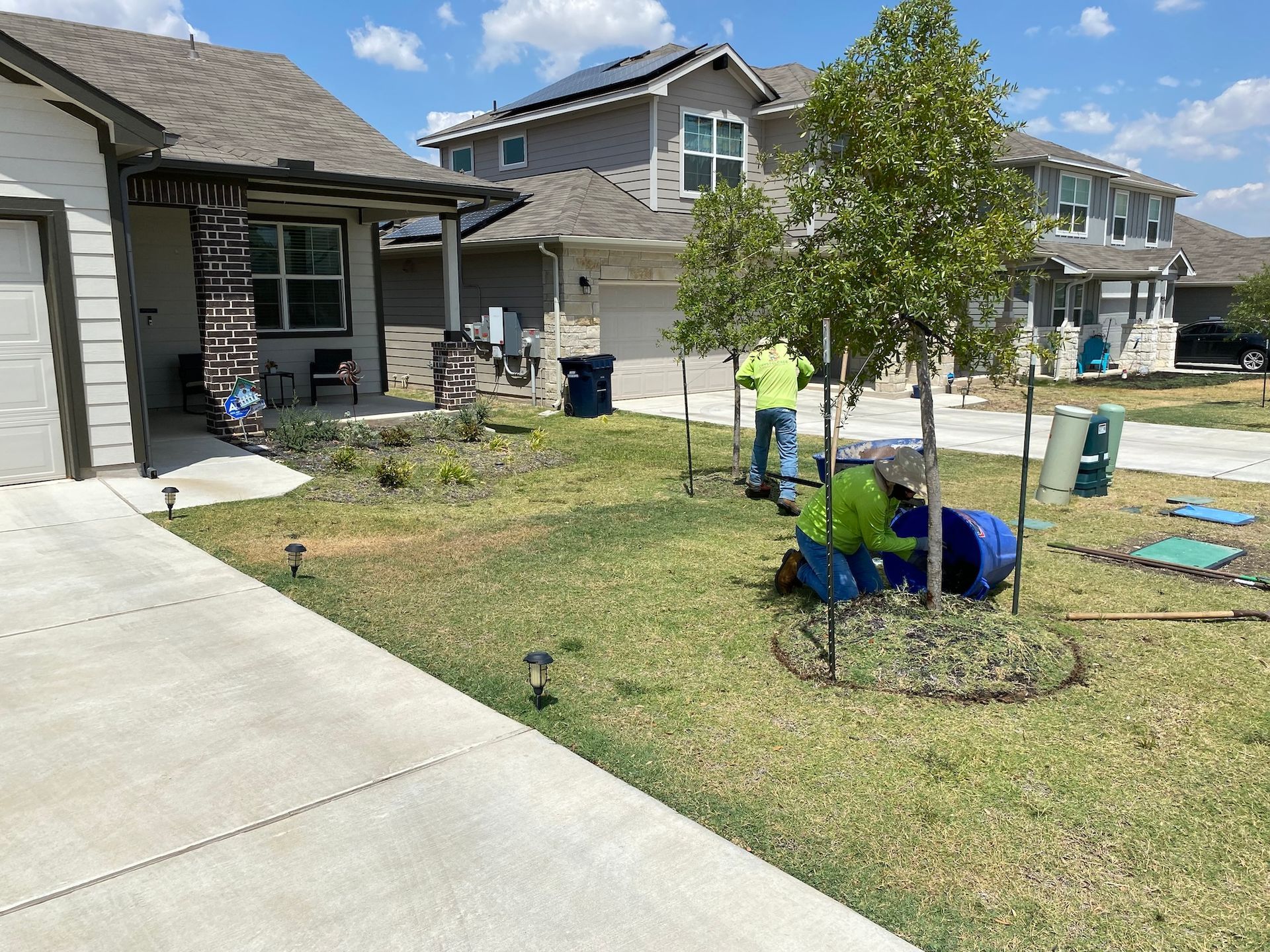 a group of people are working in a yard in front of a house .