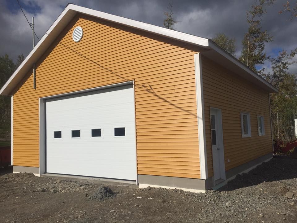 Un grand bâtiment jaune avec une porte de garage blanche