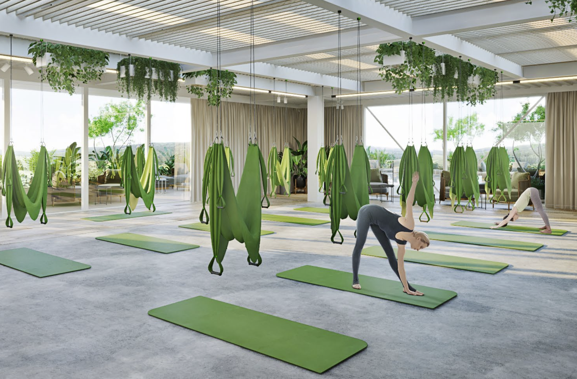 Yoga studio with green mats, hanging hammocks, and plants. Woman in grey stretching.