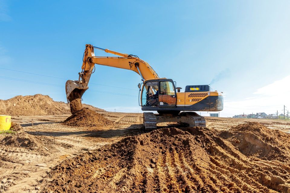 A large excavator is moving dirt on a construction site.