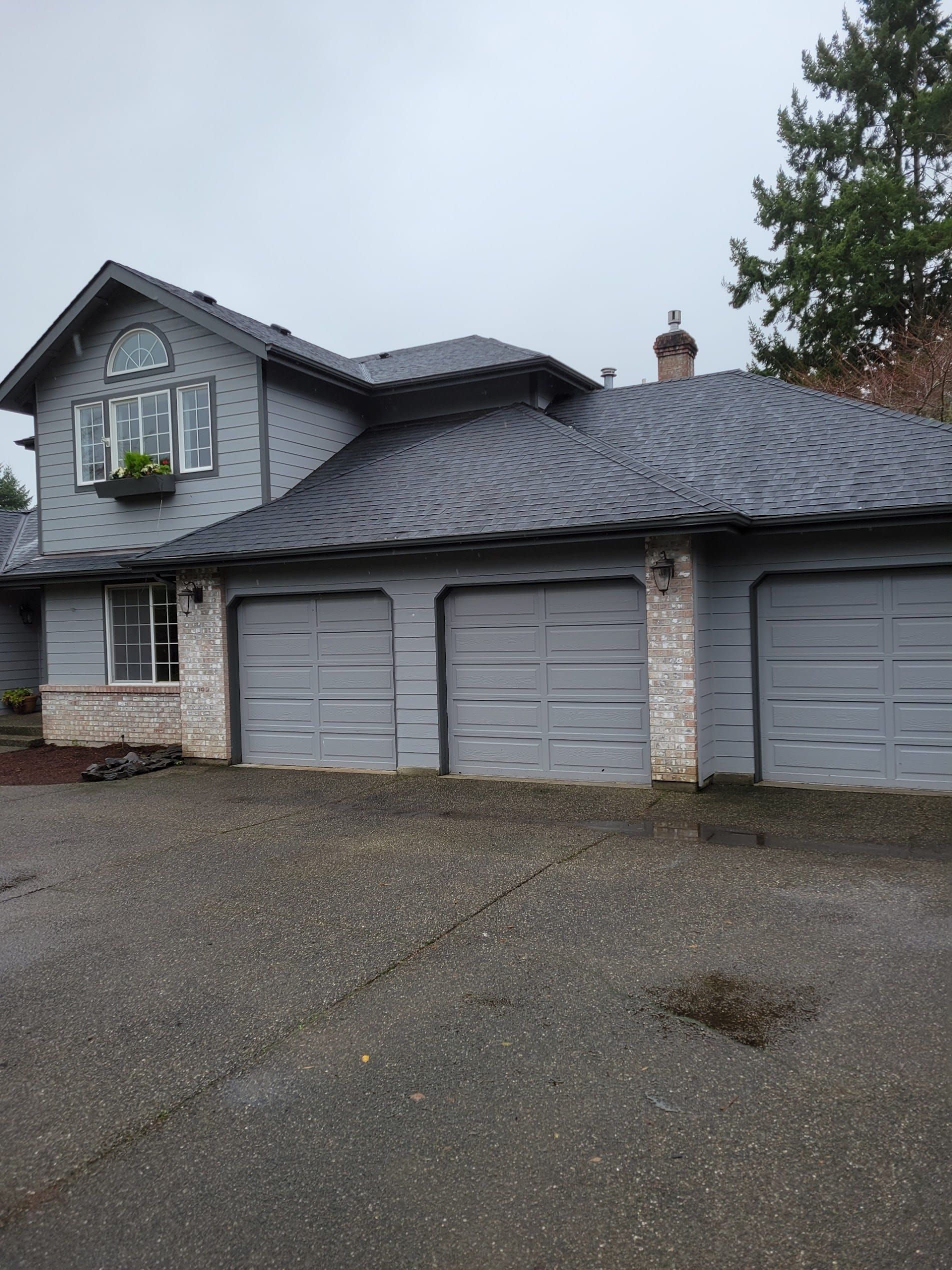 Completed roof replacement on gray two-story home
