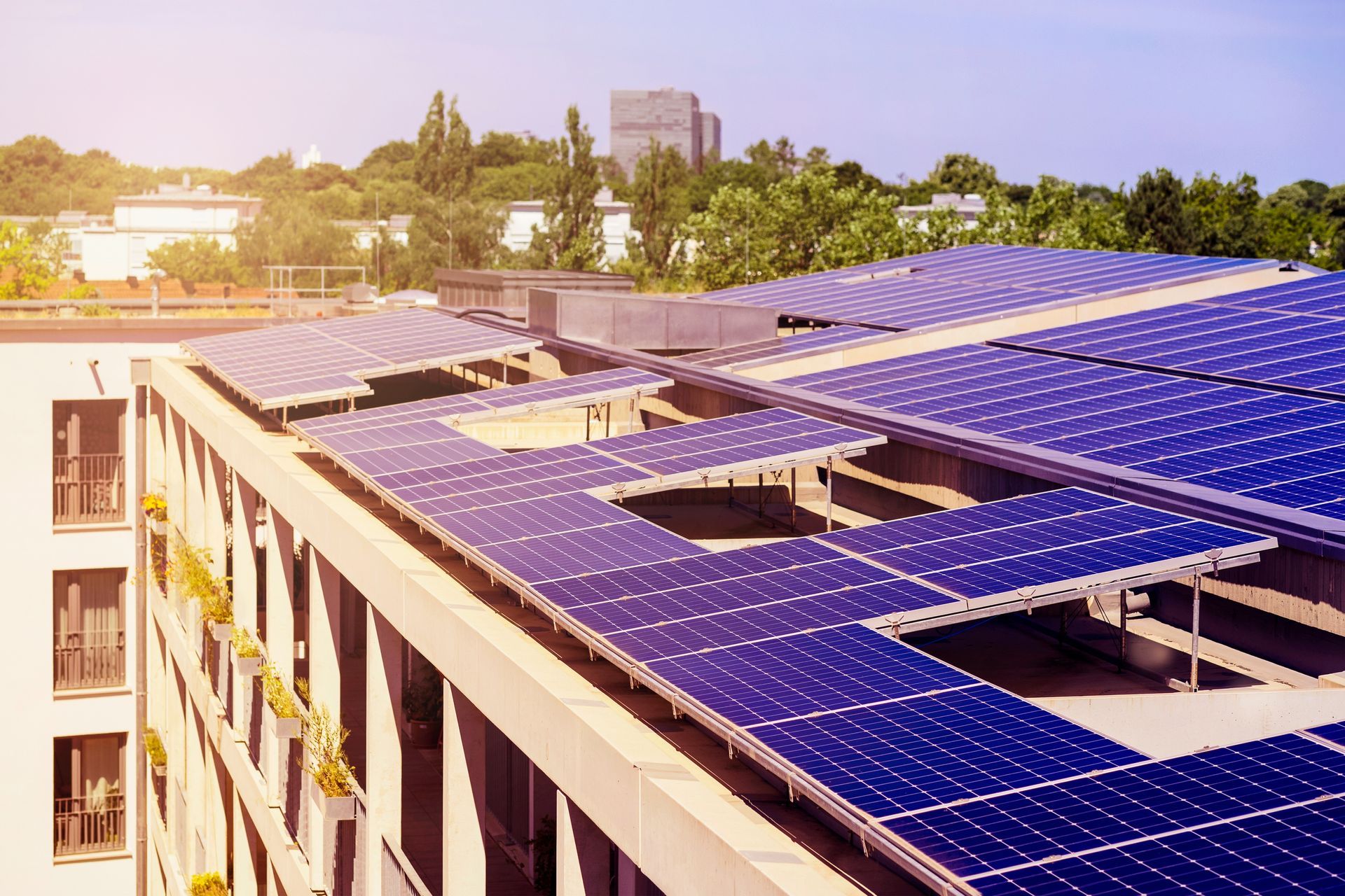 There are many solar panels on the roof of a building.