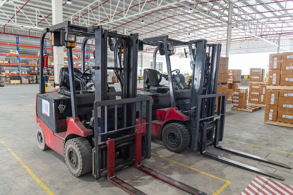 Two Forklifts Are Parked Next to Each Other in a Warehouse — Search Partners in Melbourne, VIC