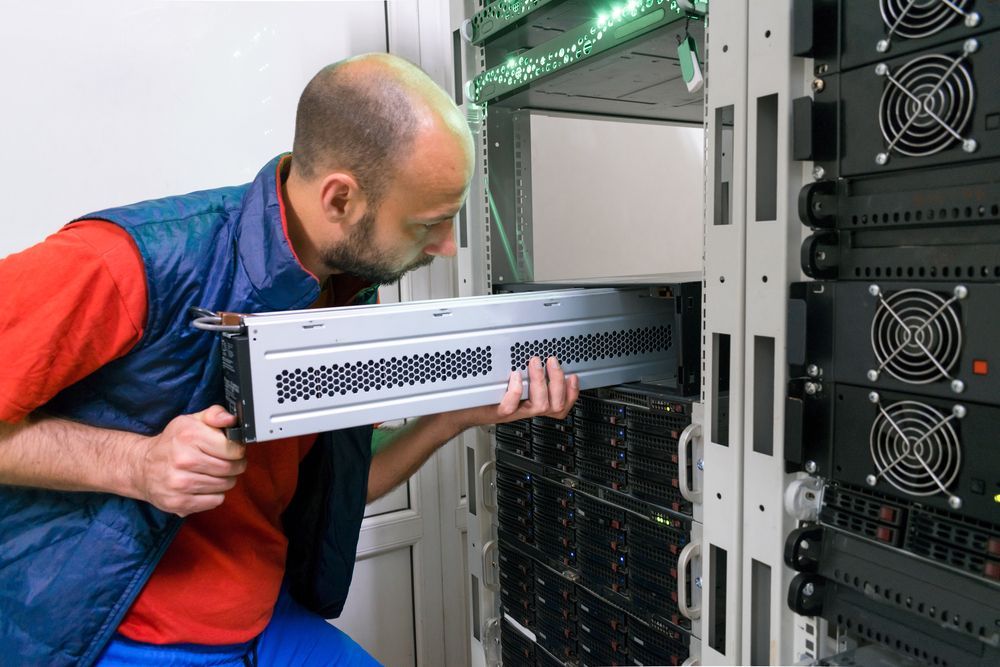 Man in Blue Vest Installing a Server in a Data Center Rack — Search Partners in Melbourne, VIC