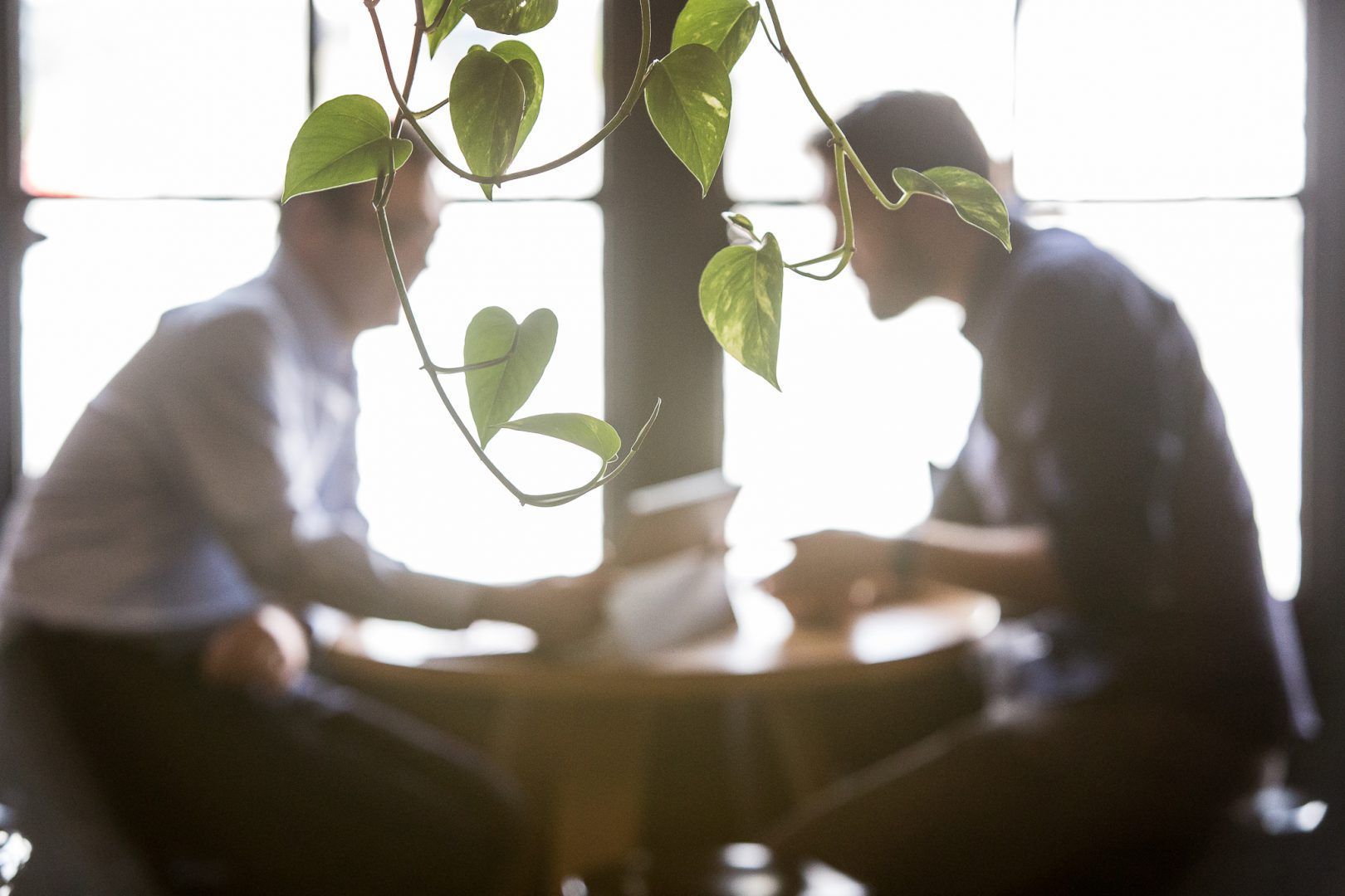 Two Men Are Sitting at a Table Talking to Each Other — Search Partners in Melbourne, VIC