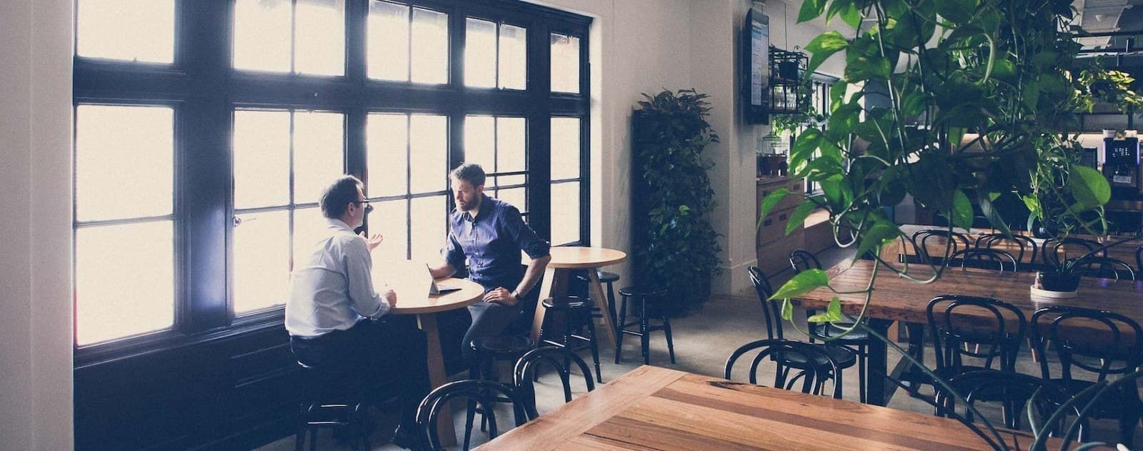 Two Men Are Sitting at a Table in a Restaurant — Search Partners in Melbourne, VIC