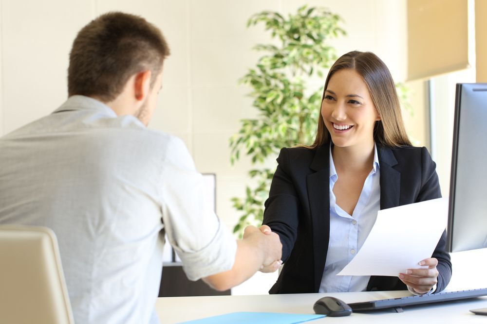 A Woman is Shaking Hands With a Man During a Job Interview — Search Partners in Canberra, ACT