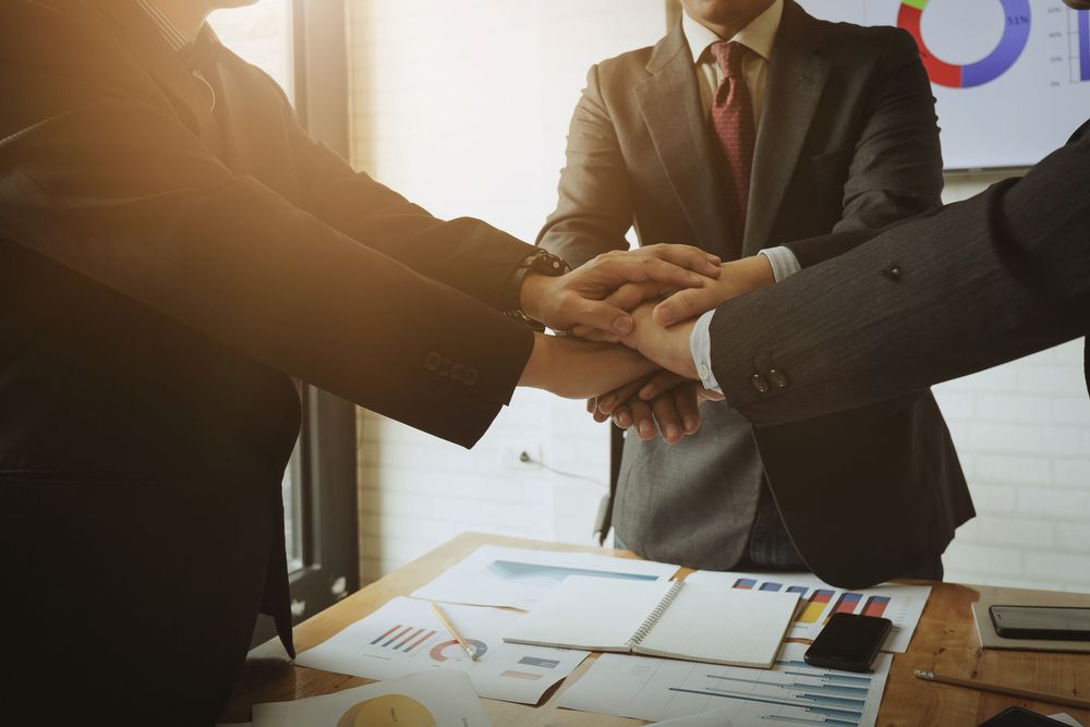 A Group of Business People Are Putting Their Hands Together — Search Partners in Sydney, NSW