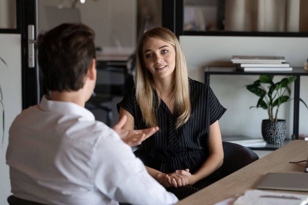 A Man and a Woman Are Sitting at a Table Having a Conversation — Search Partners in Sydney, NSW