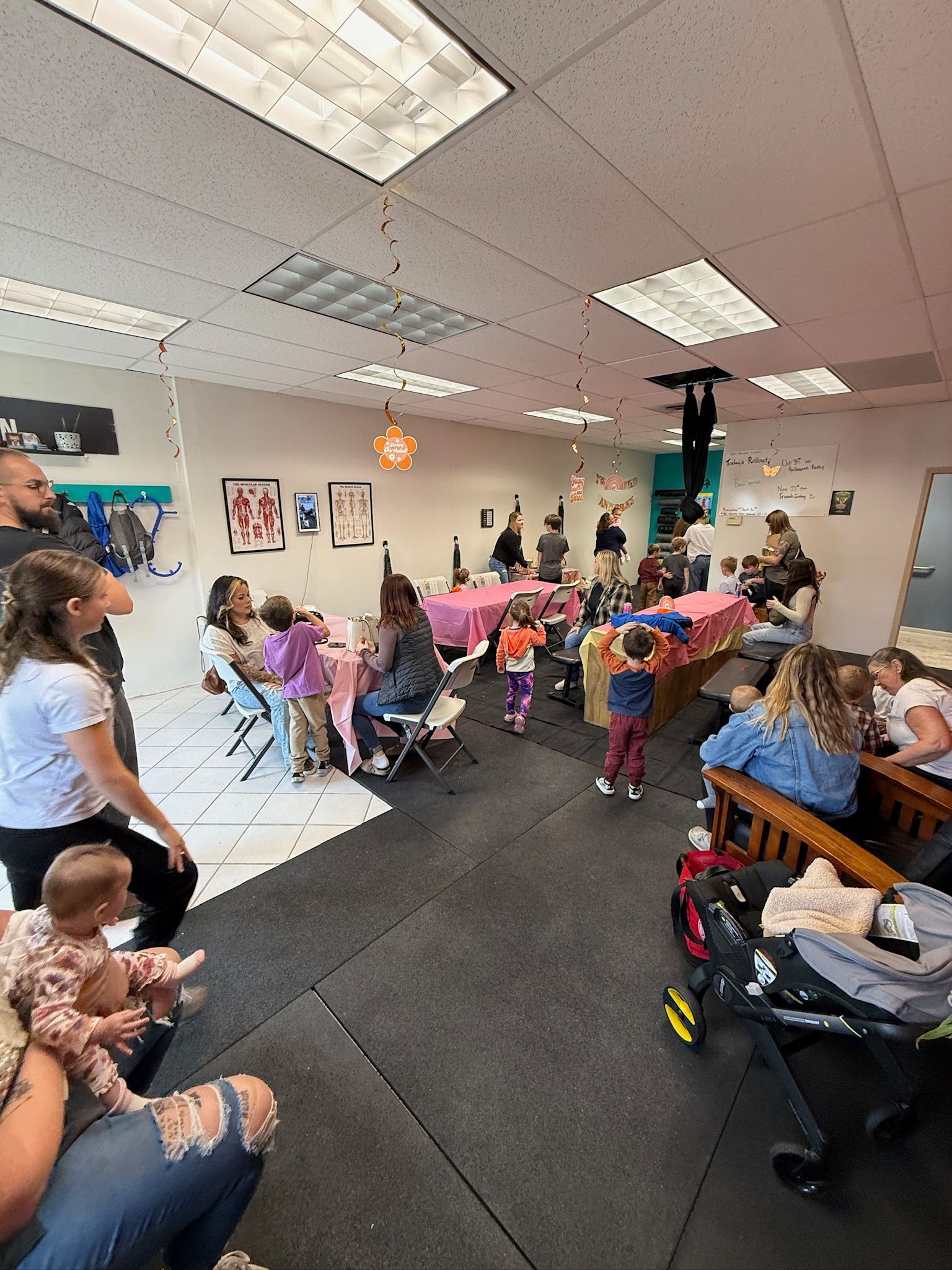 Crowded party room with children seated at decorated tables and adults standing nearby, birthday decorations visible at Everyday Strength, a gym in Wenatchee, WA