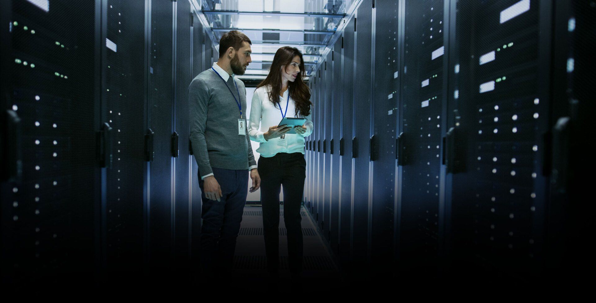 Female and Male IT Engineers Discussing Technical Details in a Working Data Center/ Server Room.