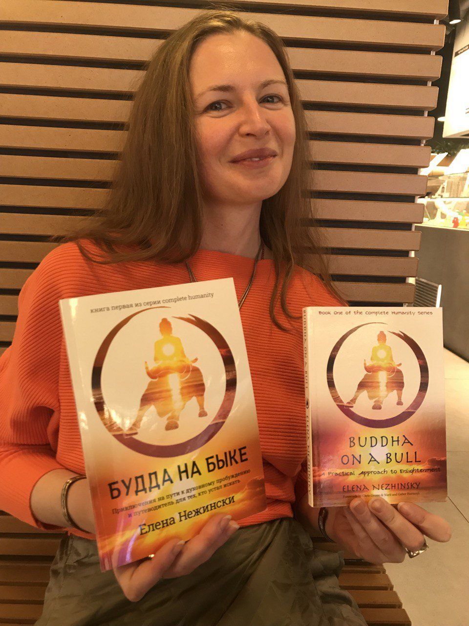 Woman holding two books titled 